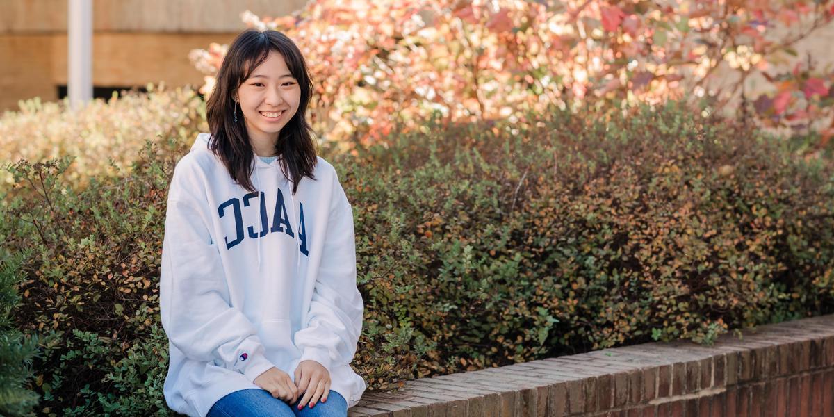 Student smiling for camera while outside.